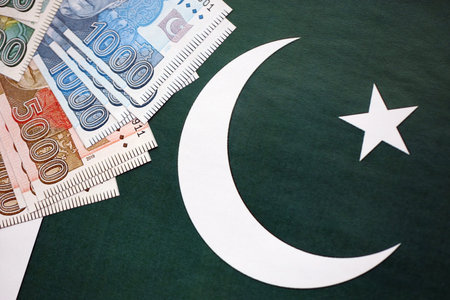 Pakistan rupees banknotes on Pakistani flag background. The current Pakistan money bills lies on banner in big amount. The concept of economics and business in Pakistanの写真素材