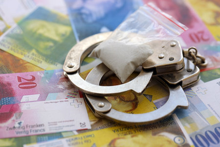 Swiss franc banknotes with handcuffs. The current francs money bills with cuffs lies on table in big...