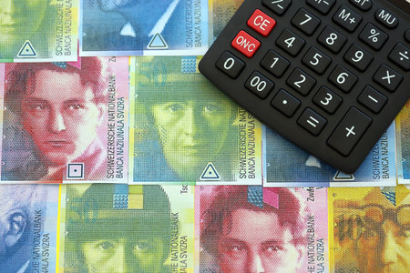 Swiss franc banknotes and calculator. The francs money bills and calc lies on table in big amount. The concept of taxation and money count in Switzerlandの写真素材