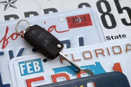Remote control car keys on US license plates with state names close up. Concept of driving in United States. Reaching a car registrationの写真素材