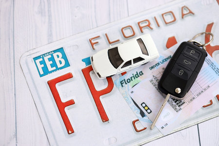Remote control car keys on Florida license plate with driver license. Concept of driving in Florida. Reaching a driving permitの写真素材