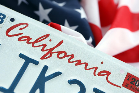USA state of California license plate on US flag. Concept of driving in California. Reaching a driving permitの写真素材