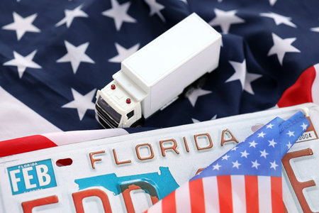 Toy truck and USA state of Florida license plate on US flag. Concept of driving in Florida. Reaching a driving permitの写真素材