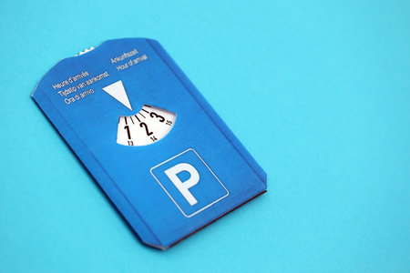 Parking disc for windshield. Limited time parking system in european countries. Concept of parking time count in busy parking lotsの写真素材