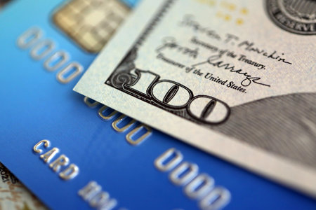 One hundred US dollar bill banknote on blue credit card for banking and payments. Concept of...