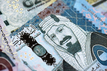 Saudi Arabia riyal money bills banknotes lies in big pile on table close up. Concept of finances and...