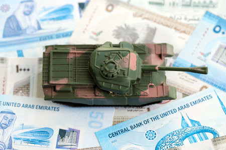 United Arab Emirates dirham currency money bills and toy tank close up. The concept of army funds...
