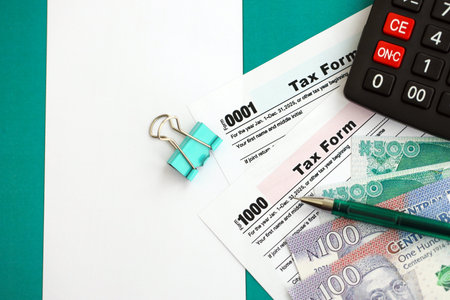 Nigerian naira money bills and calculator with tax form on flag close up. Taxation and accounting conceptの写真素材