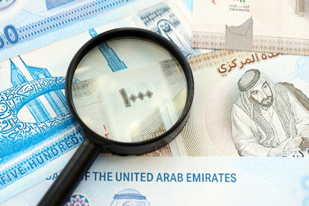 United Arab Emirates dirham currency money bills and magnifying glass close up. The concept of financial monitoring and taxationの写真素材