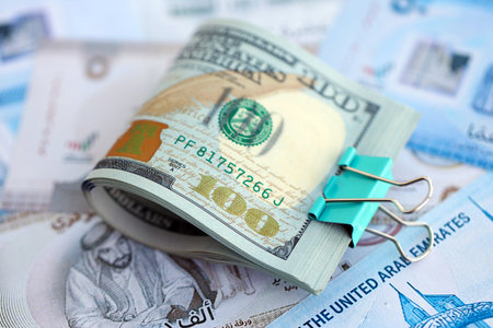 United Arab Emirates dirham currency money bills and bunch of us dollar banknotes close up. The concept of economics and currency exchangeの写真素材