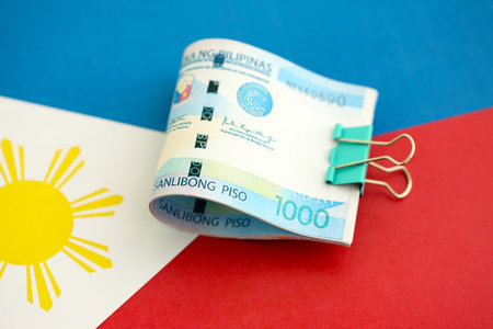 Philippines peso currency money bills lies on flag close up. The concept of business and investment