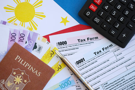 Philippines peso money bills and calculator with tax form on flag close up. Taxation and accounting conceptの写真素材