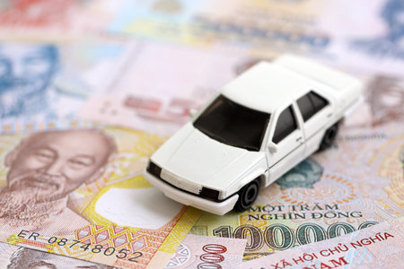 Vietnamese dong currency money bills and toy car close up. The concept of car ownershipの写真素材