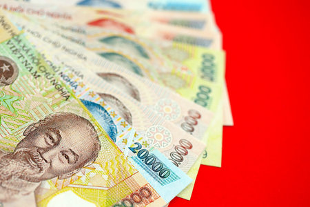 Vietnamese dong money bills in big amount close up on red. Finance and banking conceptの写真素材