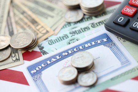 American US dollars money bills, social security number card and calculator on American flag close up. Taxpaying and insurance conceptの写真素材