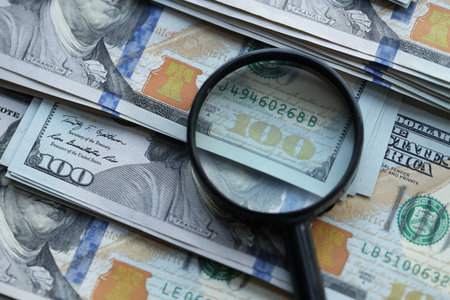 Big amount of United States USD dollar bills and magnifying glass close upの写真素材