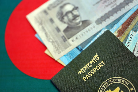 Bangladeshi taka money bills in big amount and passport lies on Bangladesh flag close up. Finance and banking conceptの写真素材