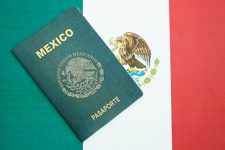 Mexican passport lies on Mexico flag close up. Travel and citizenship conceptの写真素材