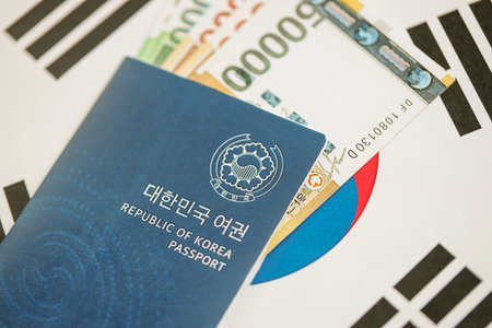 South Korean won money bills in big amount and passport lies on South Korea flag close up. Finance and banking conceptの写真素材