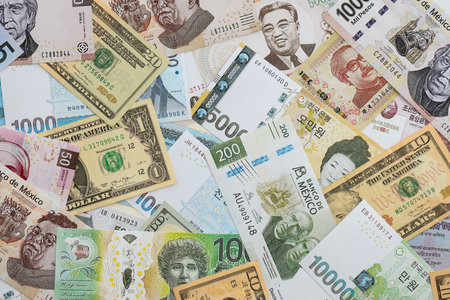 Big amount of money bills of different currencies and countries. Assortment background of international cash in big pile close upの写真素材