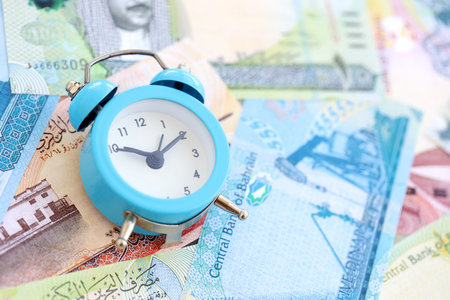Bahraini dinar currency money bills and alarm clock close up. The concept of time management and...