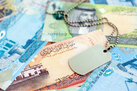 Bahraini dinar currency money bills and military token close up. The concept of army service