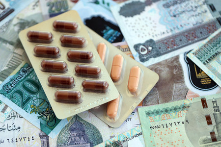 Egyptian pound currency money bills and medicine pills close up. The concept of medicine and pharmacyの写真素材