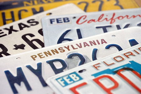Old US car license plates with various state names close up. Concept of driving in United States. Reaching a car registrationの写真素材