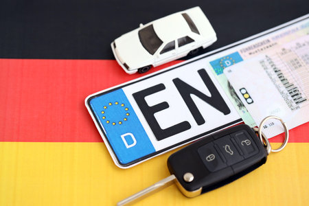 Germany Deutschland car license plate and ignition key on german flag close up. Driving permit and registration conceptの写真素材