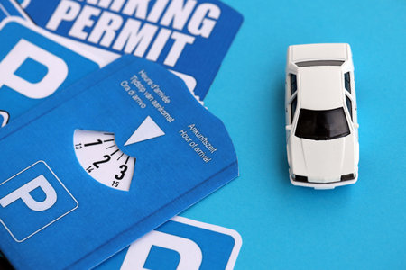 Parking permit paper notice tag and parking disc with toy car. Parking permit for people with...