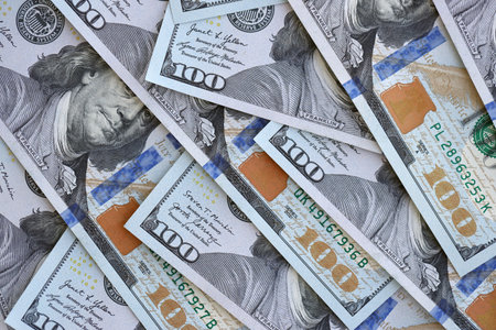 Many one hundred dollars money bills banknotes on smooth surface close up. Concept of business, rich...