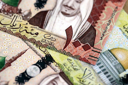 Saudi Arabia riyal money bills banknotes lies in big pile on table close up. Concept of finances and business in Saudi Arabiaの写真素材