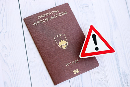Slovenia passport with exclamation sign on white wooden background close up. Problems with citizenship in Europe conceptの写真素材