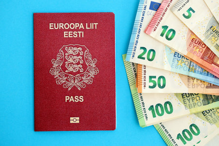 Estonia passport lies with euro money banknotes on blue background close up. Salary and pension in Europe conceptの写真素材