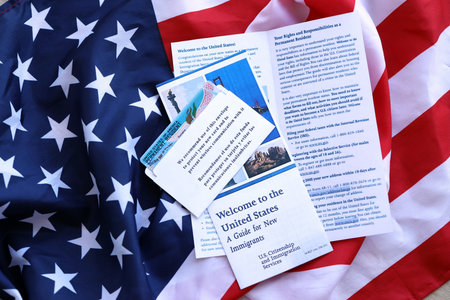 Permanent resident green card in envelope and guide for new immigrants lies on US flag close upの写真素材