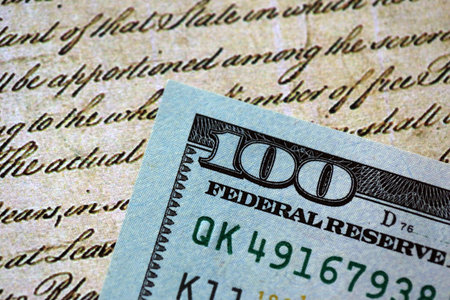One hundred US dollar bills and United States Constitution page fragment. Concept of lawsuit and corruption in United Statesの写真素材
