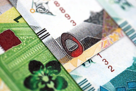 Qatari riyal money bills banknotes lies in big pile on table close up. Concept of finances and...
