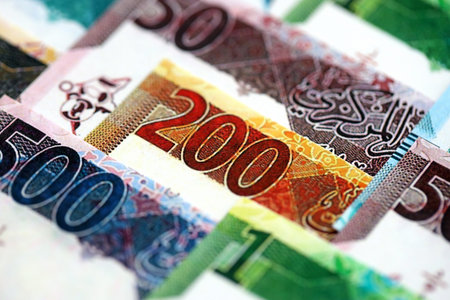 Qatari riyal money bills banknotes lies in big pile on table close up. Concept of finances and...