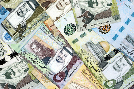 Saudi Arabia riyal money bills banknotes lies in big pile on table close up. Concept of finances and...