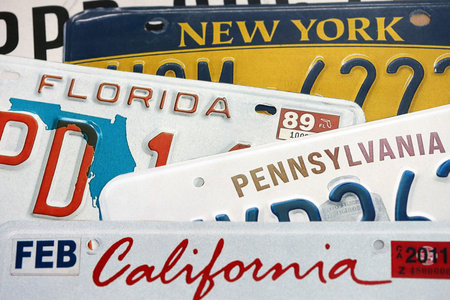 Old US car license plates with various state names close up. Concept of driving in United States....