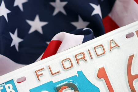 USA state of Florida license plate on US flag. Concept of driving in Florida. Reaching a driving permitの写真素材