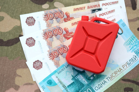 Petrol canister on russian roubles money bills on camouflage fabric. Concept of petroleum export from Russiaの写真素材