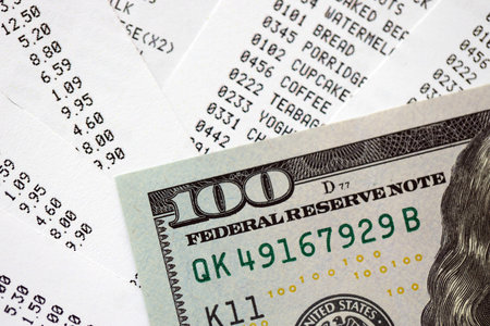 Money lose change after store visit with the store receipt. Supermarket check receipt and one hundred dollar bill close upの写真素材