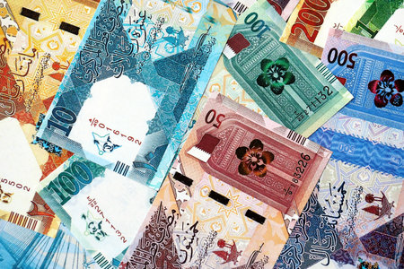 Qatari riyal money bills banknotes lies in big pile on table close up. Concept of finances and...