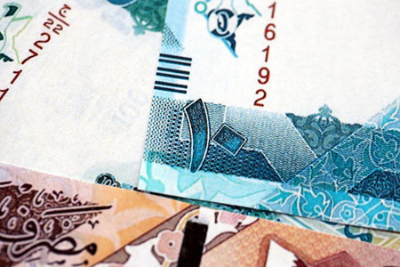 Qatari riyal money bills banknotes lies in big pile on table close up. Concept of finances and...