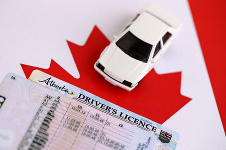 Canadian driving permit concept. Toy car and driver license on flag close upの写真素材