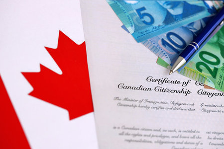 Canadian certificate of citizenship with money on Canadian flag close upの写真素材