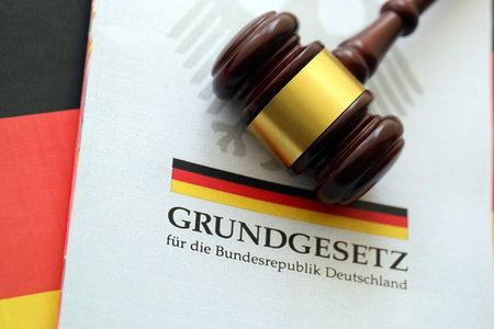 The constitution basic law book of Germany and judge hammer lies on Germany flag background close upの写真素材