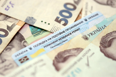 Ukrainian residence permit card or permanent resident card on Ukrainian money close up
