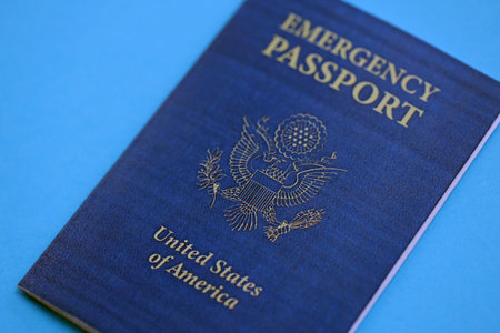 United States emergency passport book on light blue paper background close up. Travel document on blue surfaceの写真素材